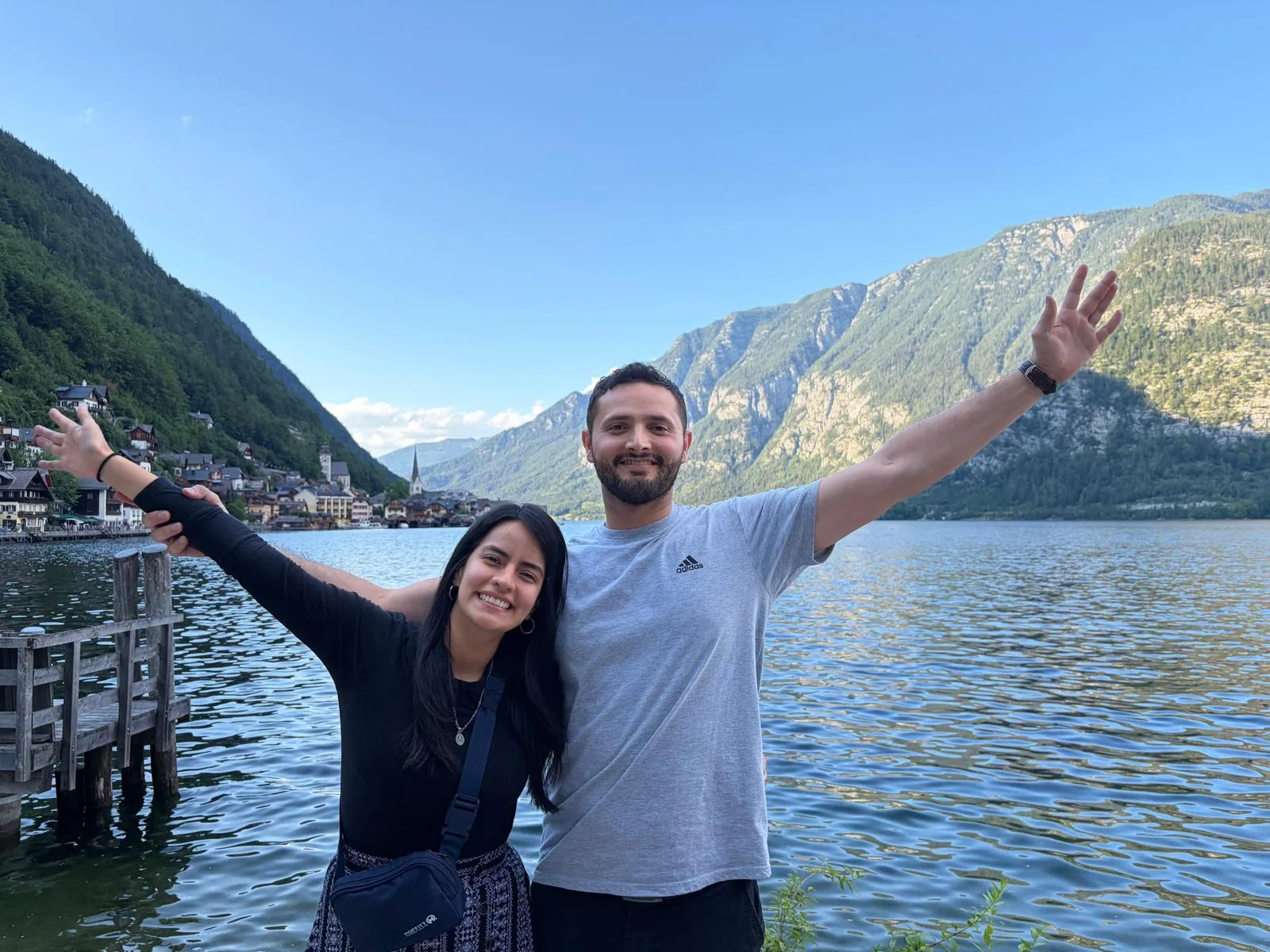 Milena y su pareja frente a un lago y montañas
